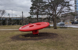 A giant red button in a park.